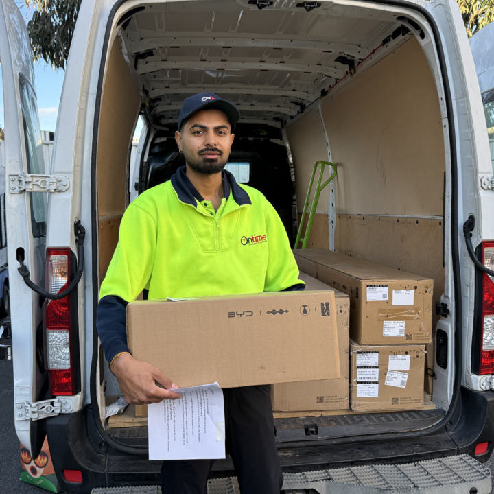 A delivery driver holding a package for final delivery.