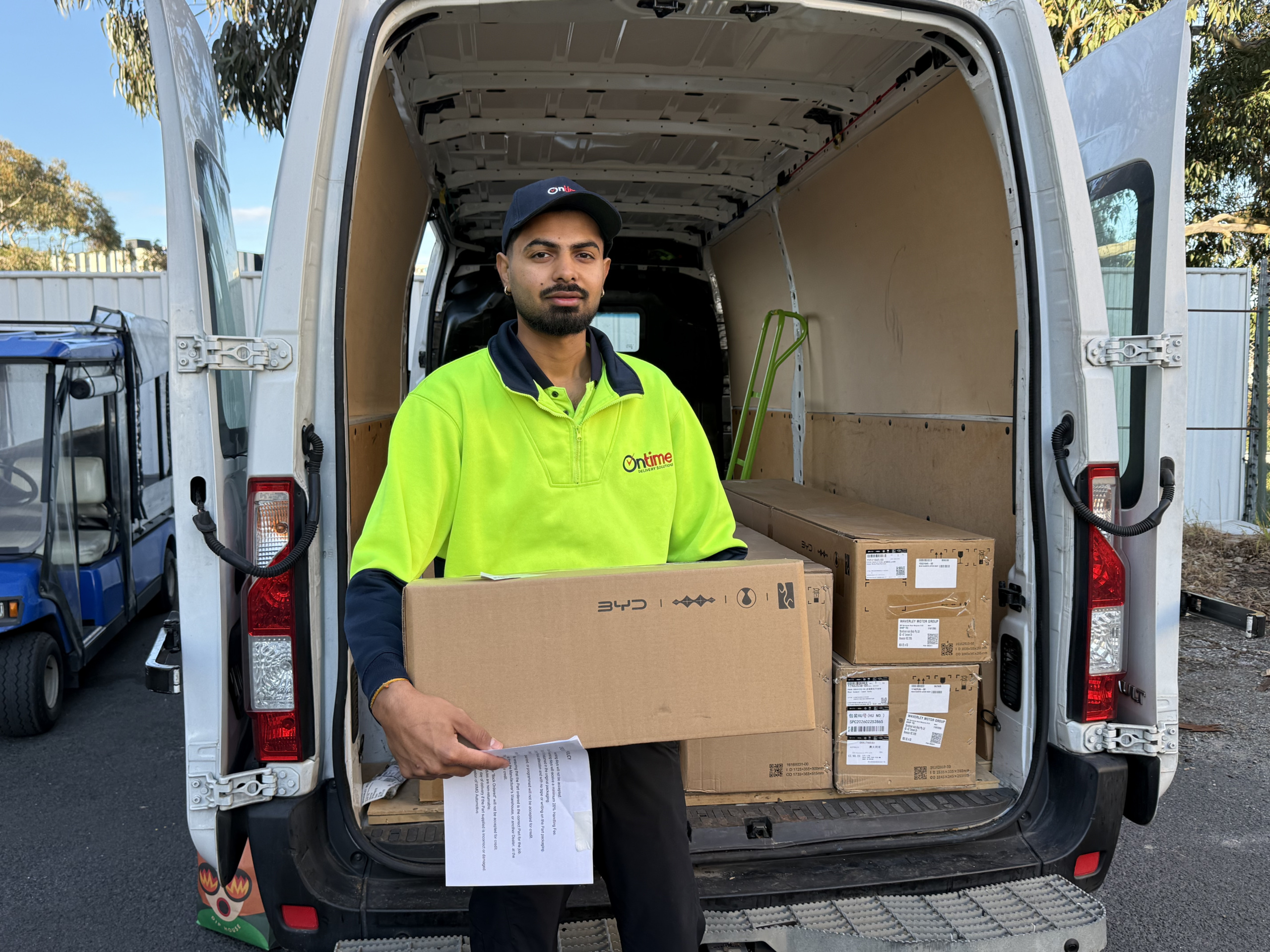 A delivery driver holding a package for final delivery.