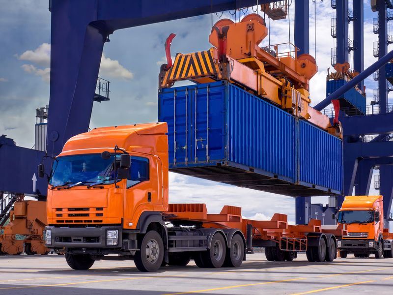 Industrial port crane lift up loading export containers box onboard from truck