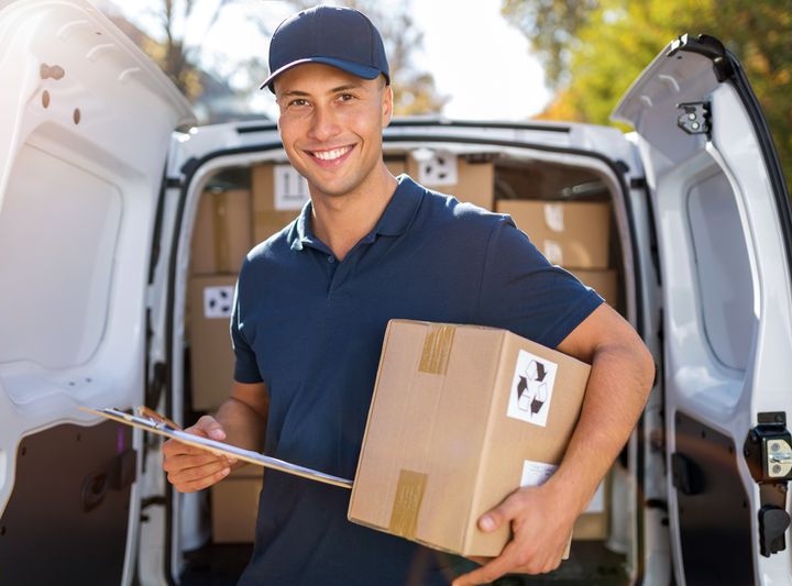 Delivery man standing in front of his van