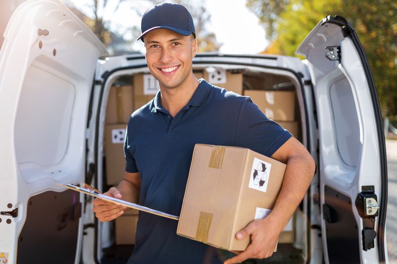 Delivery man standing in front of his van