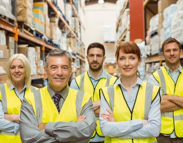 Smiling warehouse team with arms crossed