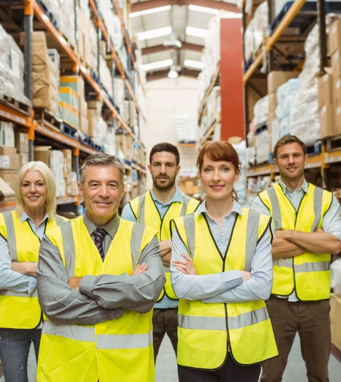 Smiling warehouse team with arms crossed
