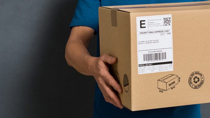 Closeup hands of delivery man holding package to deliver. Courie