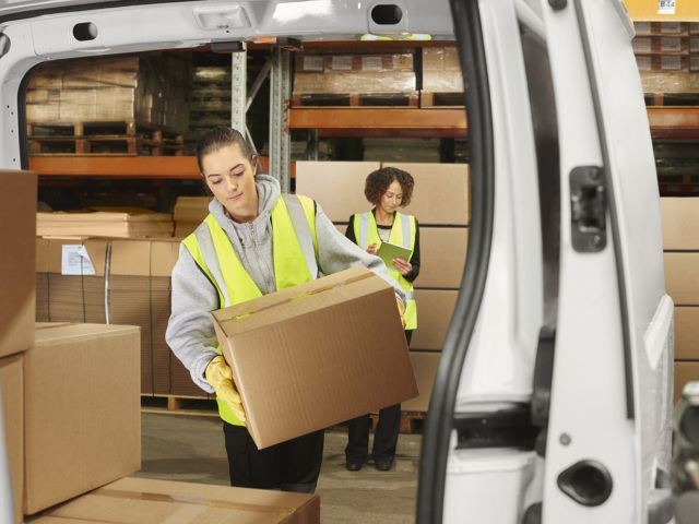 Warehouse staff loading freight on delivery van